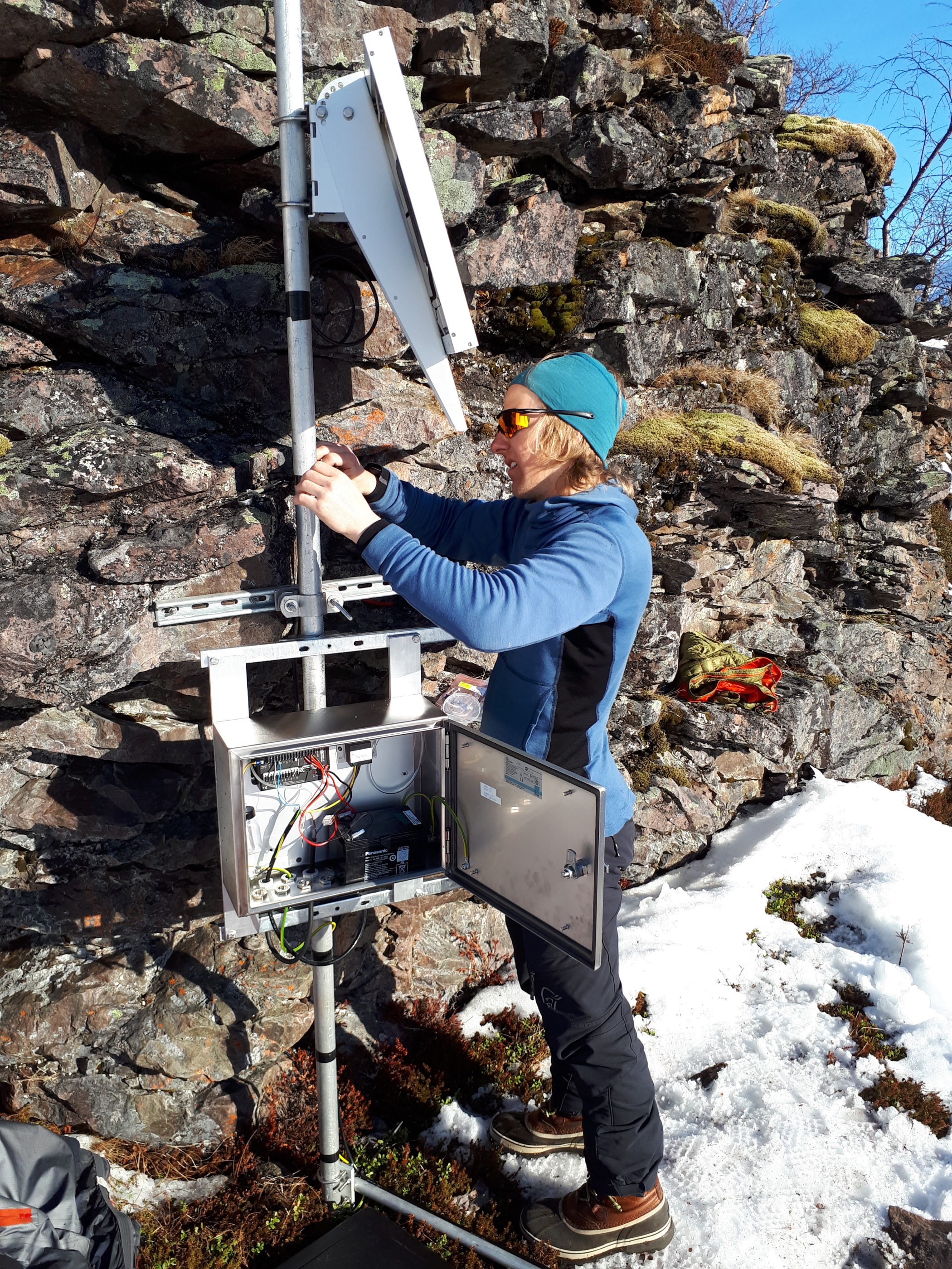 Bild 2: Robin Andersson monterar solpanel för ny avbördningsstation i Tarfala jokken. Fotograf: Torbjörn Karlin.